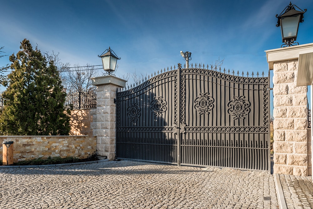 Black metal driveway gates with finial tips